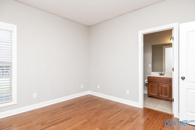 unfurnished room with light hardwood / wood-style flooring and sink