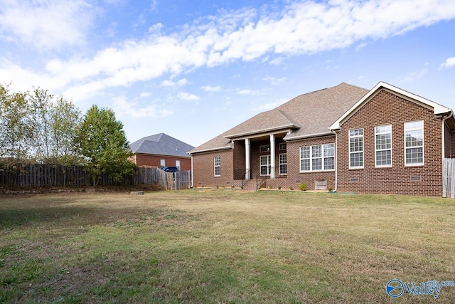 rear view of property featuring a yard