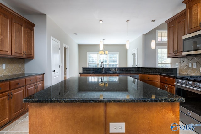 kitchen with sink, appliances with stainless steel finishes, a center island, and decorative backsplash