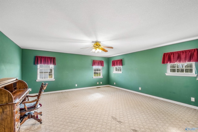 office space with carpet, ceiling fan, and a textured ceiling