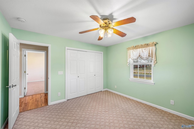 unfurnished bedroom featuring ceiling fan, light carpet, and a closet