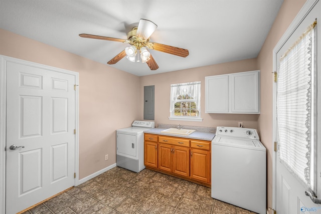 clothes washing area with electric panel, ceiling fan, sink, and cabinets