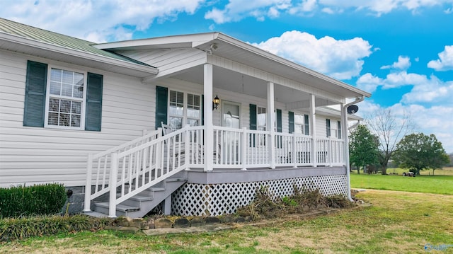 entrance to property with a lawn and covered porch