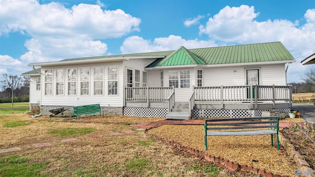 rear view of house featuring a wooden deck