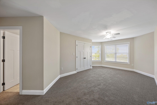 empty room featuring carpet floors, ceiling fan, and baseboards