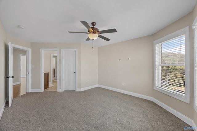 unfurnished bedroom with light carpet, multiple windows, and baseboards