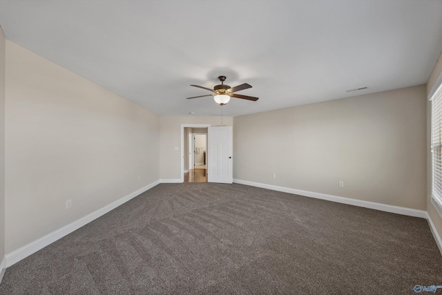empty room with visible vents, baseboards, a ceiling fan, and dark colored carpet