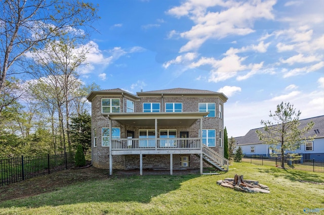 back of house featuring a deck, a yard, a fenced backyard, stairs, and brick siding
