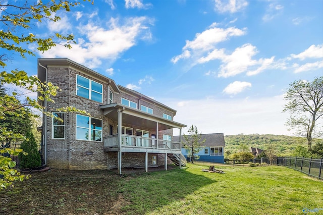 back of property featuring a deck, a yard, a fenced backyard, stairs, and brick siding