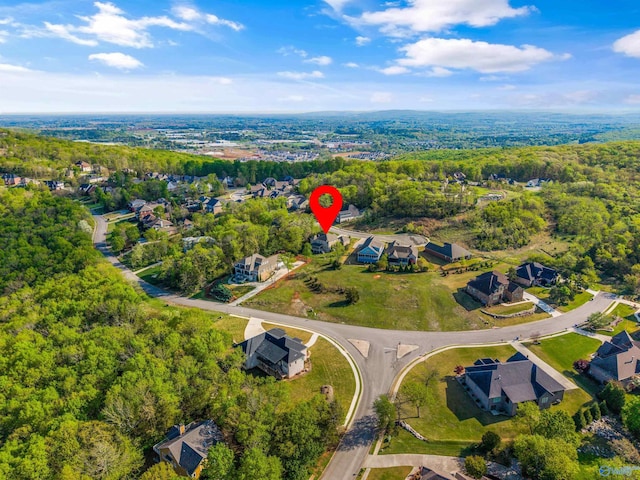 drone / aerial view with a wooded view and a residential view