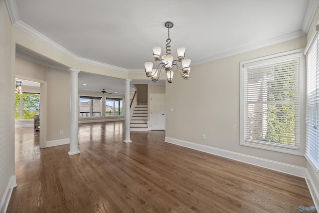 unfurnished dining area with ornate columns, ornamental molding, a chandelier, dark wood-style flooring, and baseboards