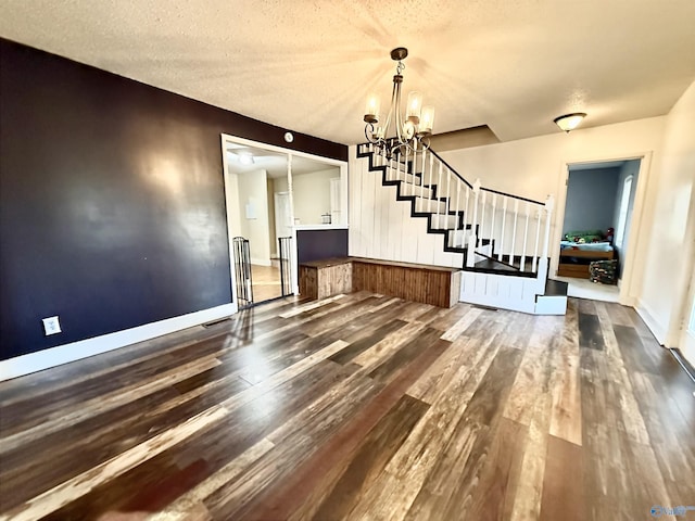 interior space with an inviting chandelier, dark hardwood / wood-style floors, and a textured ceiling