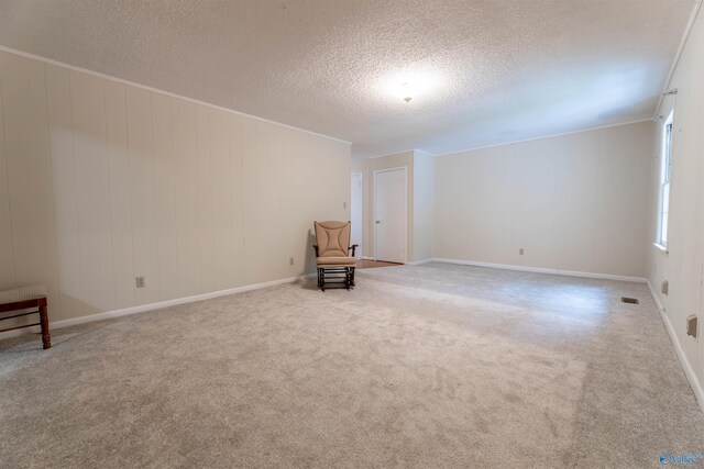 unfurnished room featuring visible vents, carpet, a textured ceiling, and baseboards
