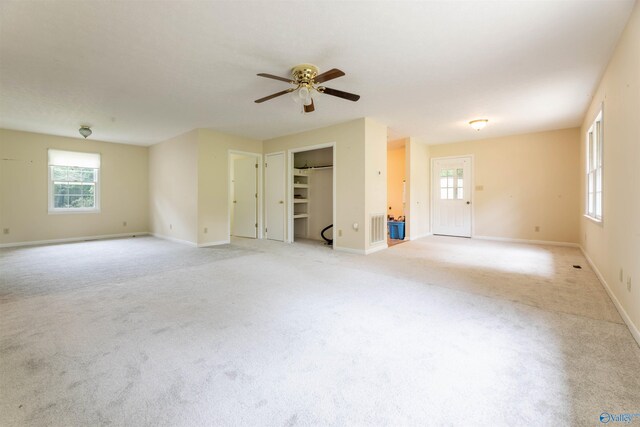 empty room featuring ceiling fan, light carpet, and baseboards