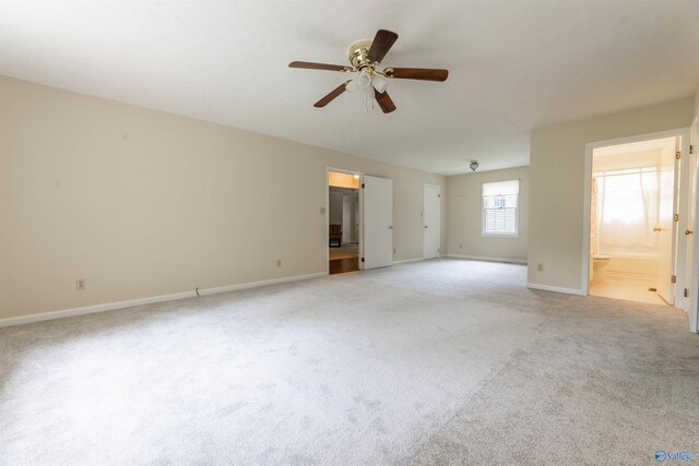 empty room with baseboards, a ceiling fan, and light carpet
