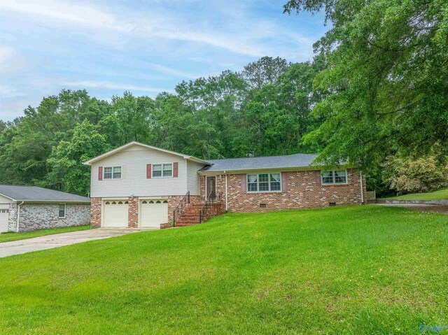 tri-level home featuring an attached garage, driveway, crawl space, and a front yard