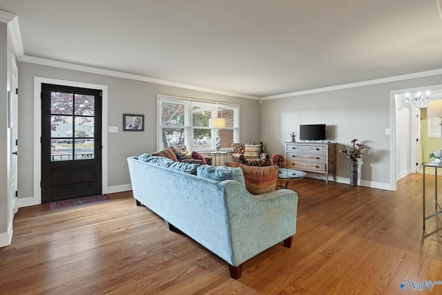 living room featuring ornamental molding, hardwood / wood-style floors, and an inviting chandelier