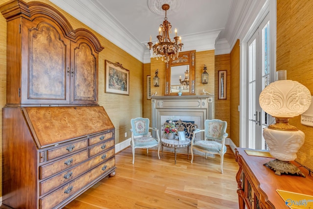 sitting room featuring light hardwood / wood-style flooring, a chandelier, and crown molding