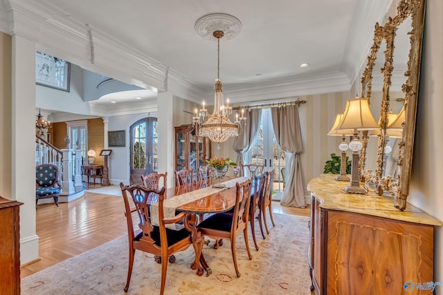 dining space featuring french doors, light wood-type flooring, a wealth of natural light, and ornamental molding