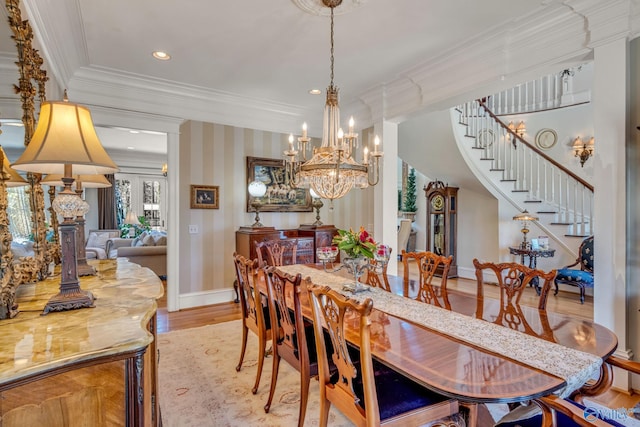 dining room with an inviting chandelier, light wood-type flooring, and crown molding