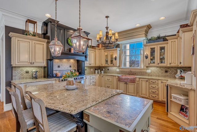 kitchen featuring light hardwood / wood-style flooring, decorative light fixtures, a center island, and a breakfast bar