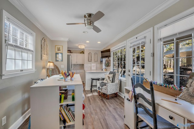 interior space featuring light wood-type flooring, ceiling fan, crown molding, and plenty of natural light