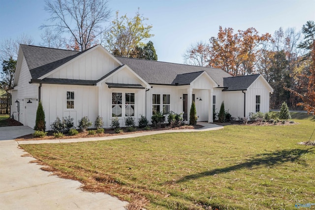 modern farmhouse featuring a front yard and a garage