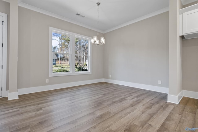 unfurnished dining area with light hardwood / wood-style floors, ornamental molding, and a chandelier