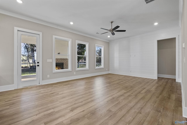 unfurnished living room with crown molding, light hardwood / wood-style flooring, ceiling fan, and a brick fireplace