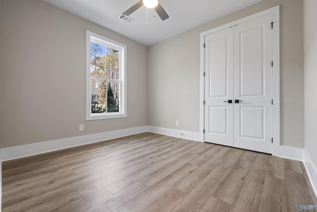 unfurnished bedroom featuring ceiling fan, light hardwood / wood-style floors, and a closet