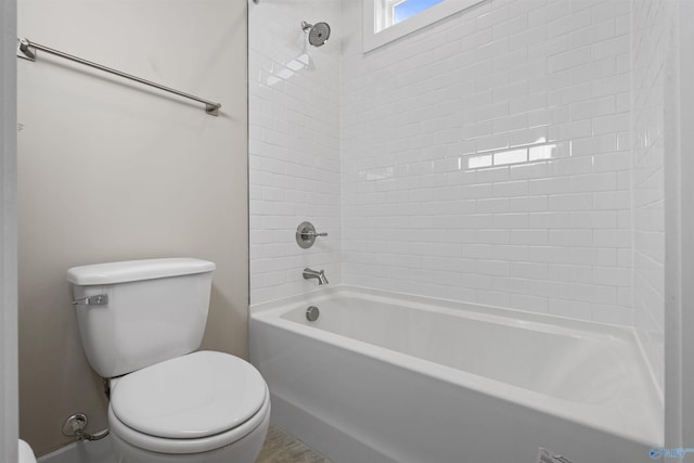 bathroom featuring tiled shower / bath and toilet