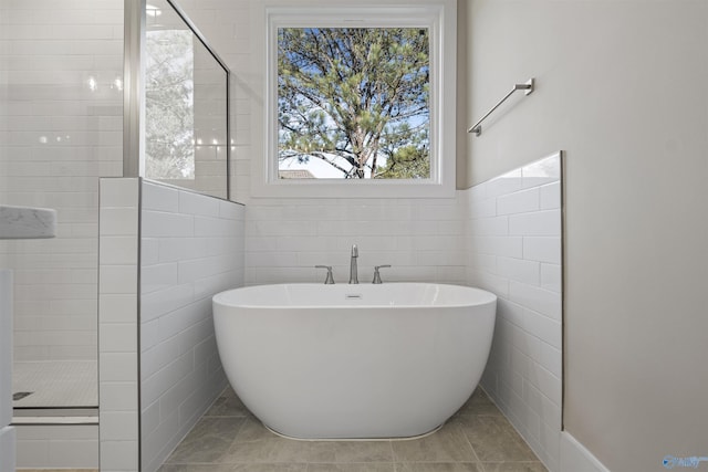 bathroom featuring tile patterned flooring, a healthy amount of sunlight, and plus walk in shower