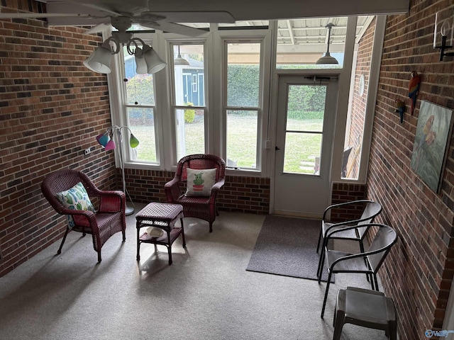 sunroom / solarium featuring carpet flooring, french doors, and brick wall