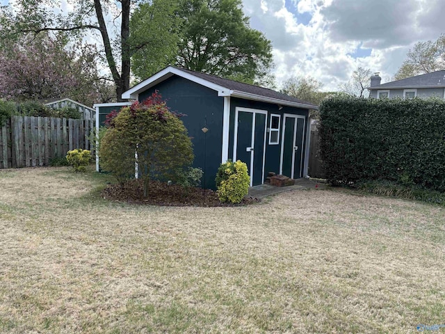 view of outdoor structure with fence and an outbuilding