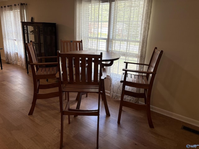 dining area featuring visible vents, wood finished floors, and baseboards