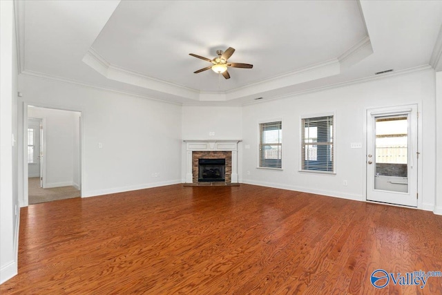 unfurnished living room with ornamental molding, a wealth of natural light, and a raised ceiling