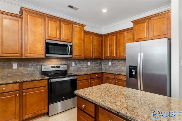 kitchen with crown molding, appliances with stainless steel finishes, light stone counters, and light tile patterned floors