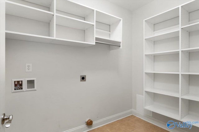 clothes washing area with hookup for a washing machine, light tile patterned floors, and hookup for an electric dryer