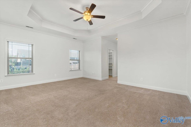 unfurnished room with light carpet, a raised ceiling, ornamental molding, and ceiling fan