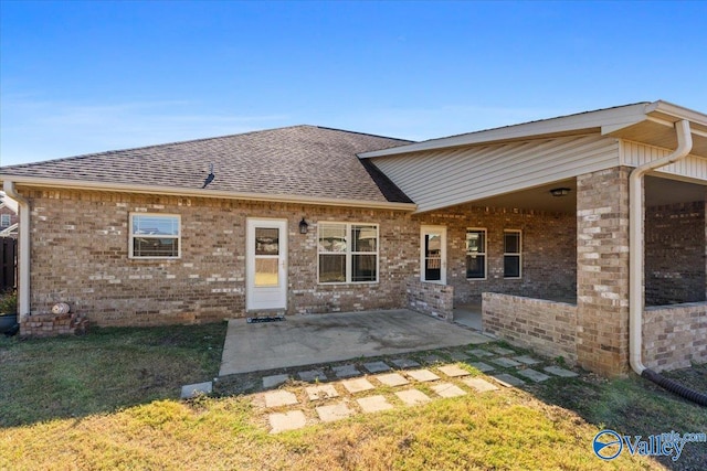 back of property featuring a yard and a patio