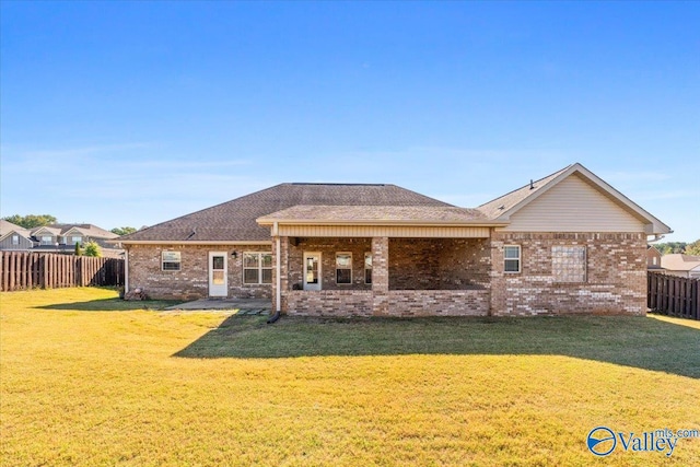 rear view of house featuring a lawn