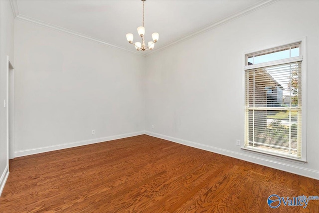 spare room featuring an inviting chandelier, ornamental molding, and hardwood / wood-style flooring