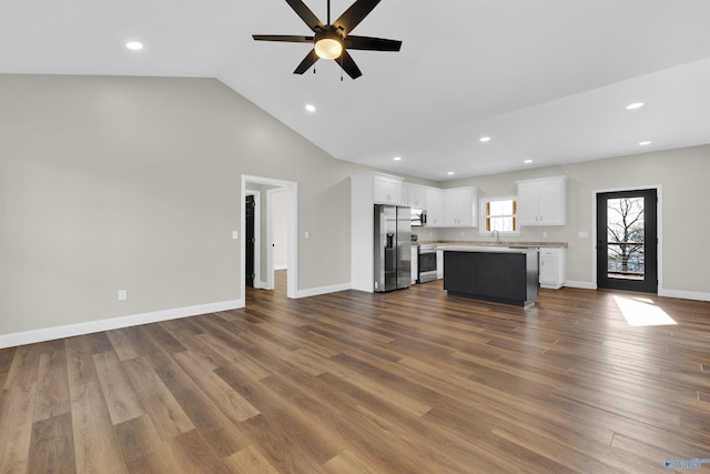 unfurnished living room featuring dark wood finished floors, baseboards, and ceiling fan