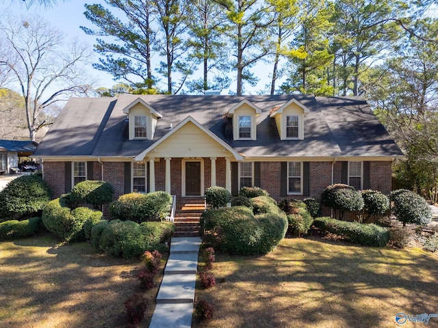 new england style home with a front lawn and covered porch