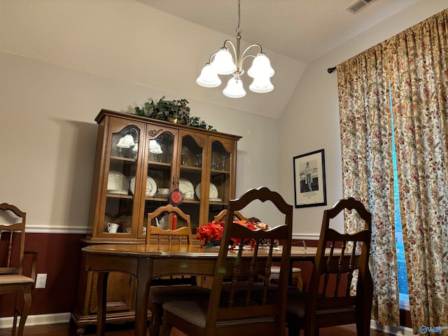 dining area featuring vaulted ceiling and a chandelier