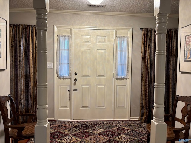 entrance foyer featuring a textured ceiling and ornamental molding