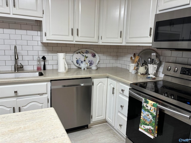 kitchen with white cabinets, appliances with stainless steel finishes, and sink