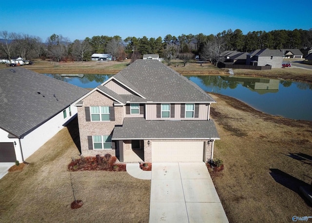 front facade featuring a water view, a front lawn, and a garage