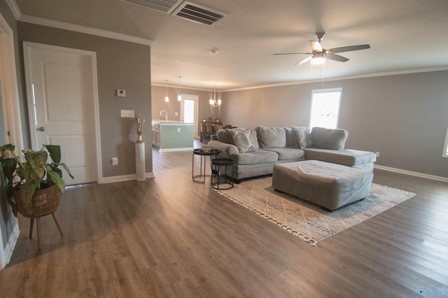 living room featuring ceiling fan with notable chandelier, dark hardwood / wood-style flooring, and ornamental molding