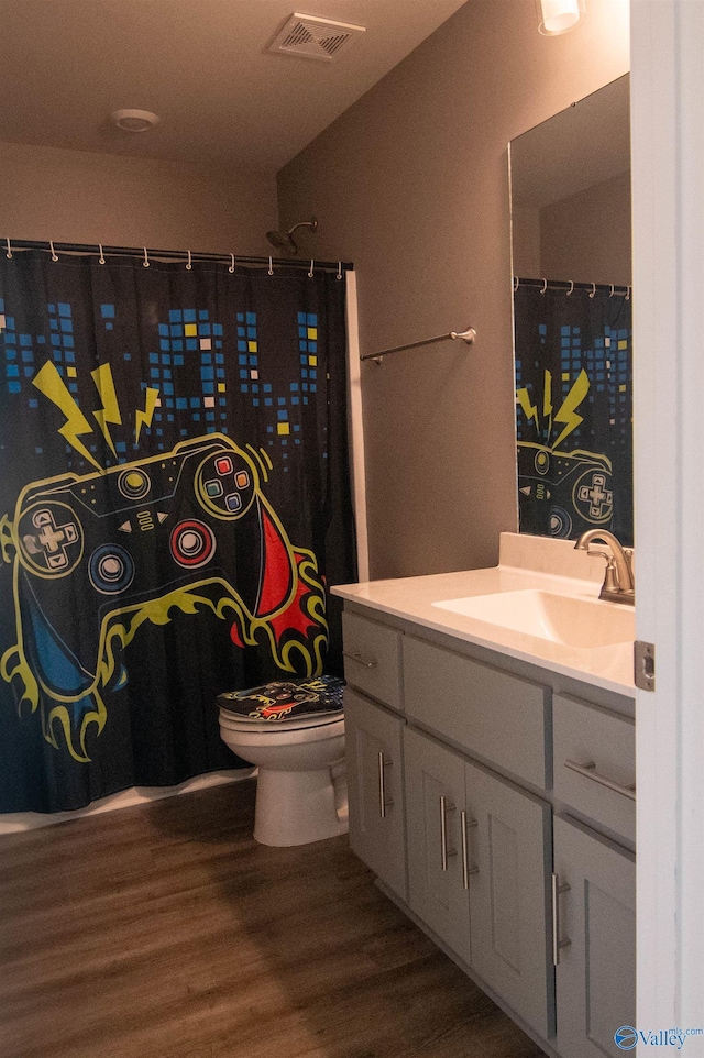 bathroom featuring vanity, toilet, and hardwood / wood-style floors